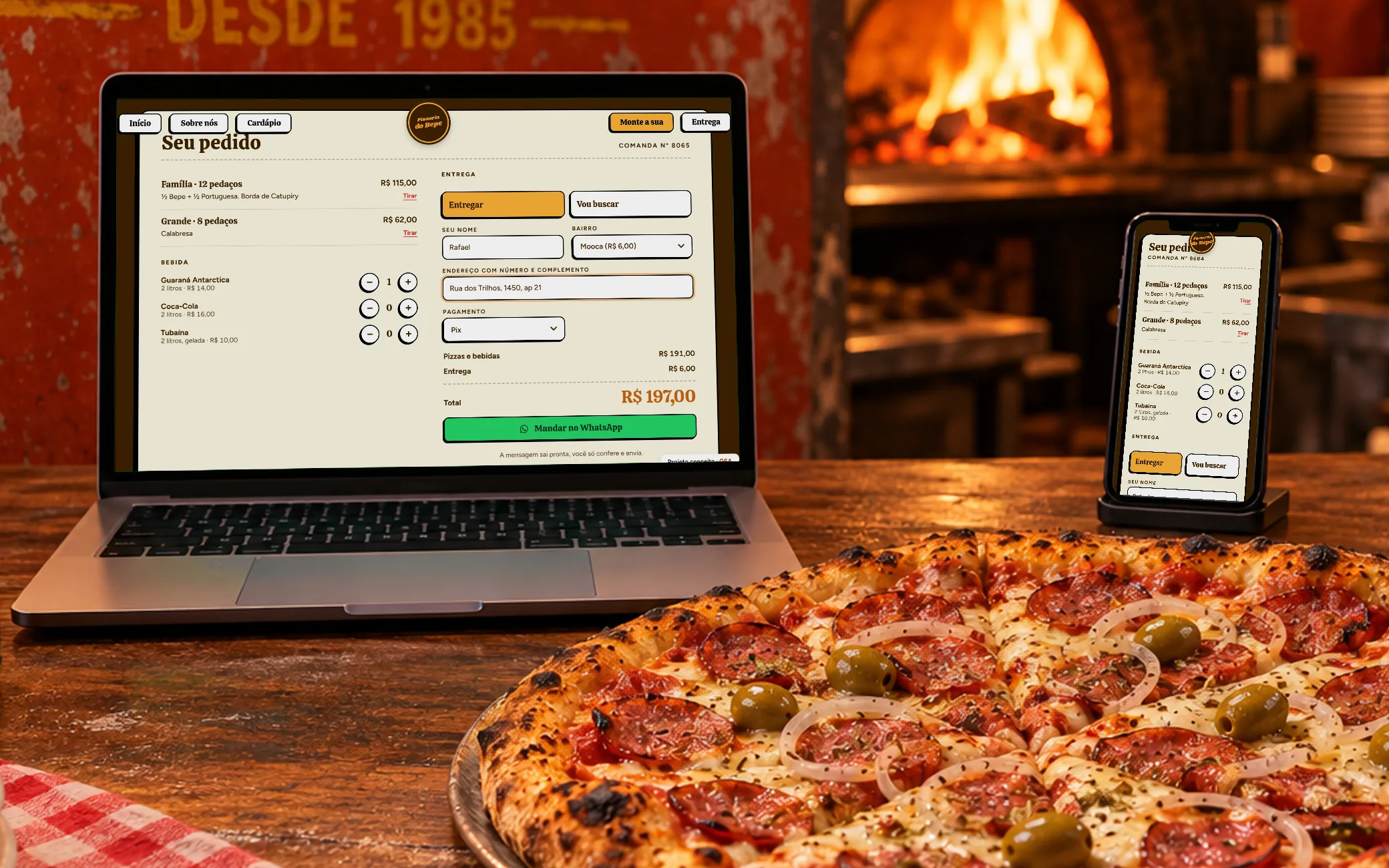 Notebook e celular com a comanda: duas pizzas, guaraná, entrega na Mooca e o total